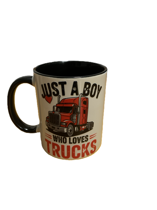 A ceramic coffee mug with a cream-colored exterior, black interior and handle, featuring a graphic of a red semi-truck and the text 'JUST A BOY WHO LOVES TRUCKS'.
