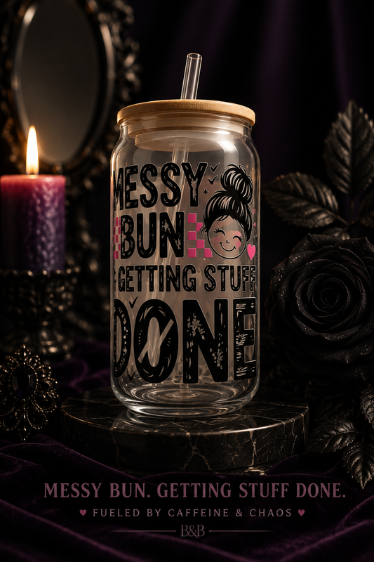 Glass tumbler with straw lid featuring text and a messy bun illustration on a dark background.